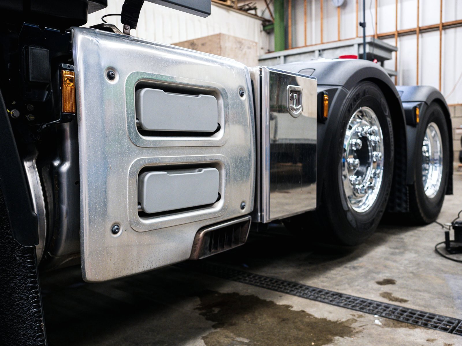 Polished fuel tank and alloy wheels on a tractor standing in a bright shop